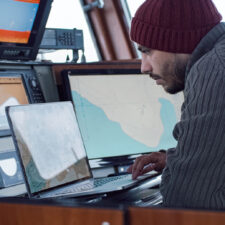 commercial fishing captain reviews NPFVOA schedule on a laptop
